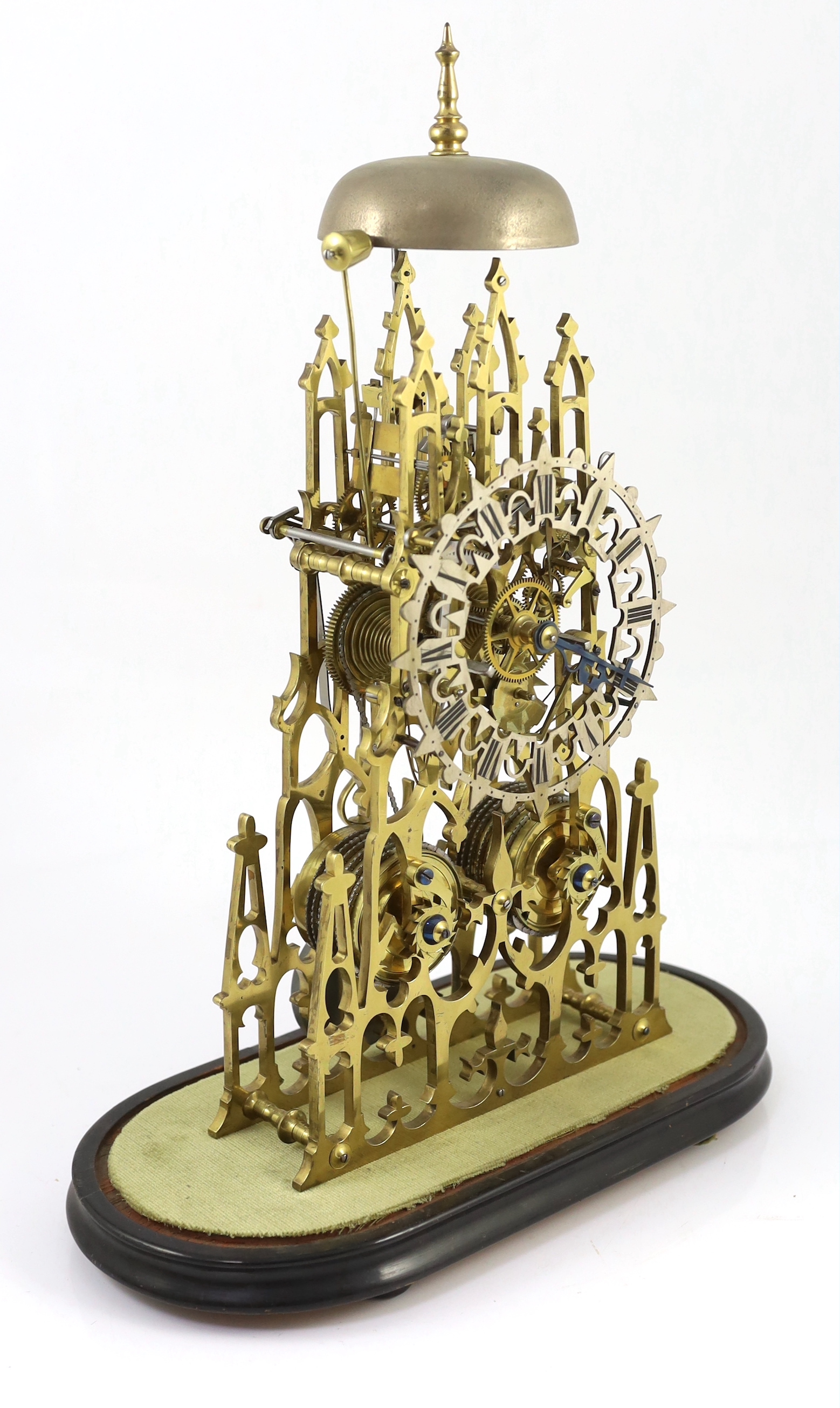 A Victorian brass cathedral skeleton clock, 46cm high, with ebonised stand and glass dome, overall 52cm high